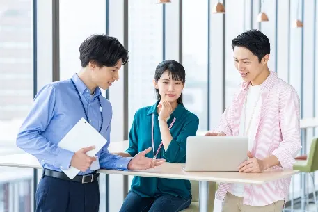 支援担当者と社内メンバーが同じ画面を見ながら業務を実装する様子